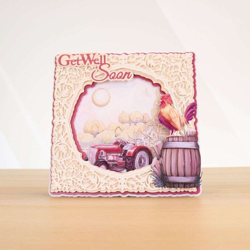 Card made using Beautifully Brisk Special Edition Vignette with a tractor and cockerel stood on a barrel and a filigree around the edges of the card