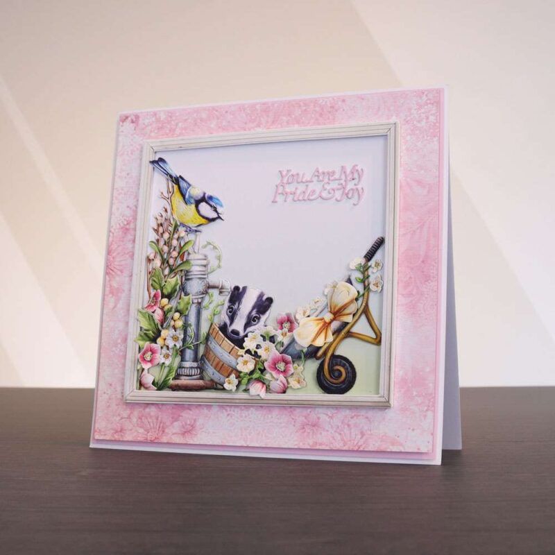 Card made using Spring's Garland Special Edition Vignette with a blue tit and badger playing in a garden, surrounded by florals
