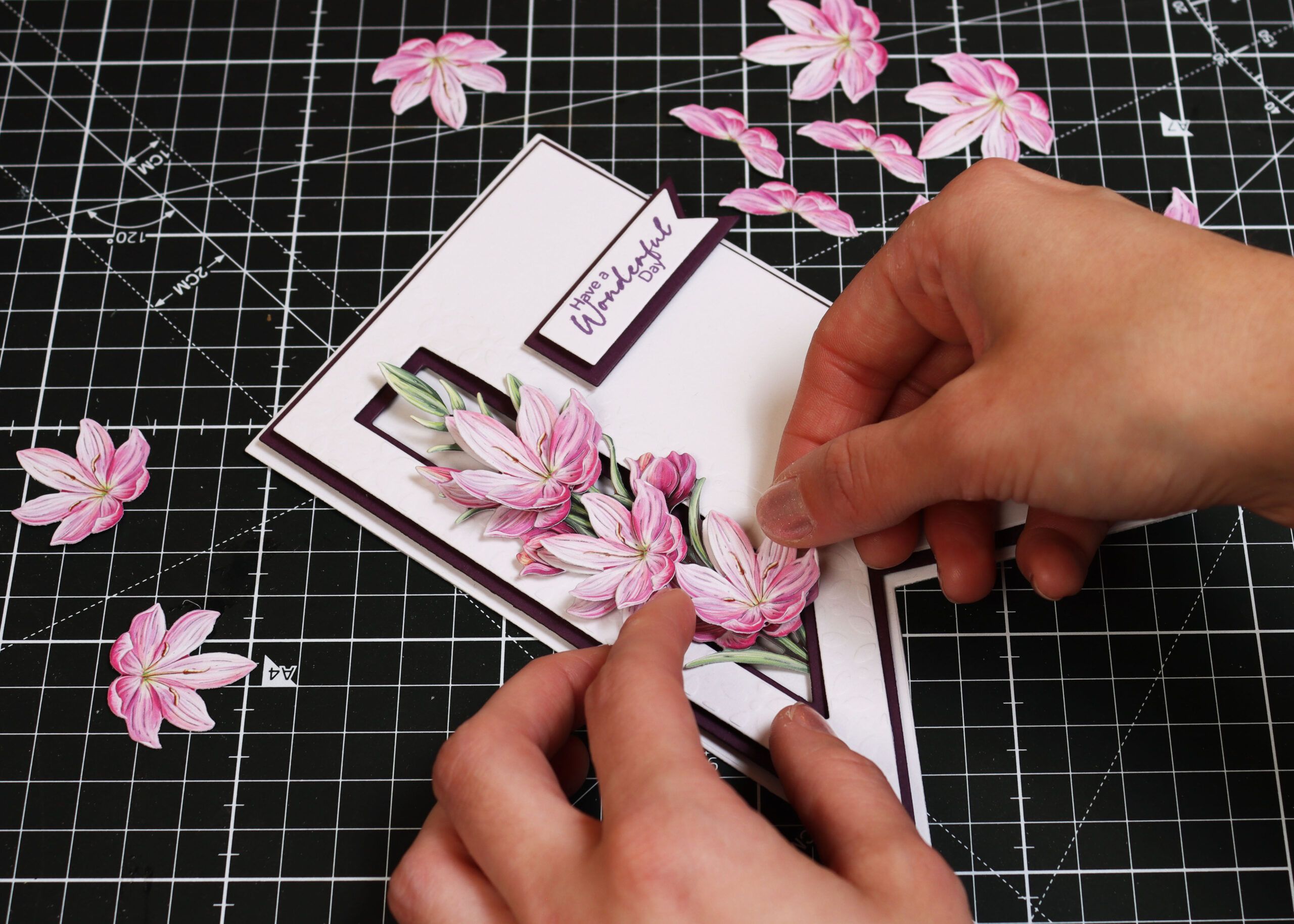 Hands crafting a card using die cut artwork