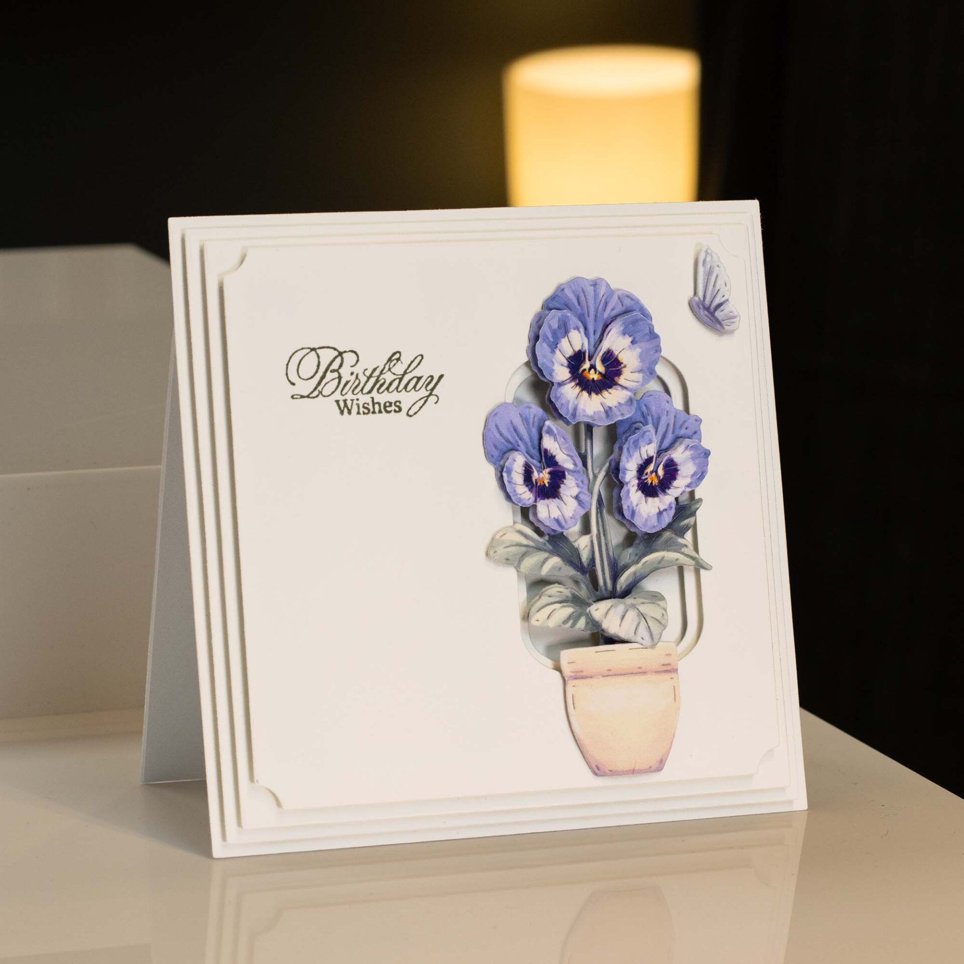a card made with the precious pansies die cutting kit with white layers