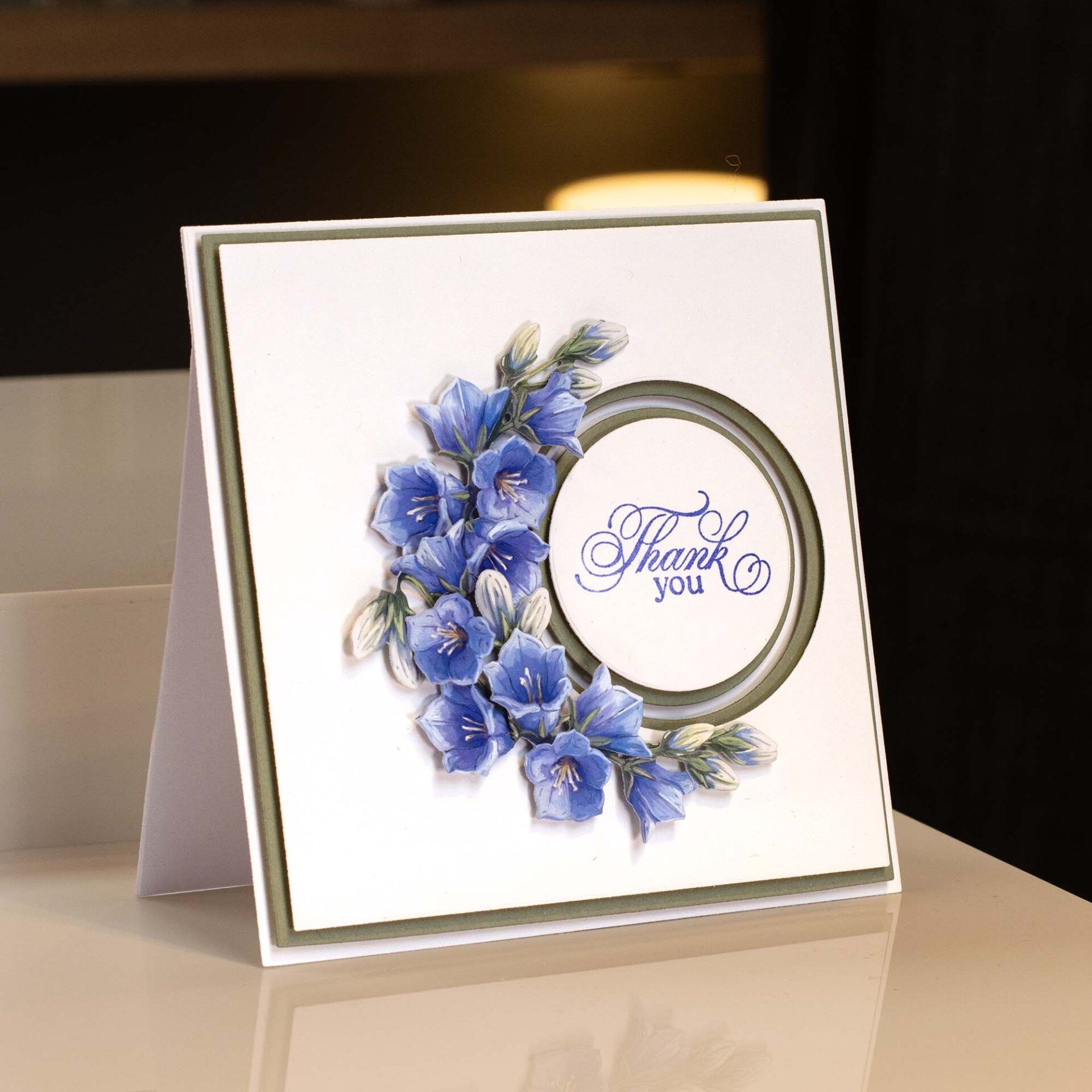 a simple square card with blue flowers curved around a circular aperture